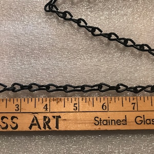 May include: Black metal chain links, likely for hanging stained glass art. The chain is measured with a wooden ruler, showing lengths in inches. The text "GLASS ART" and "Stained Glass Studio" are visible on the ruler.