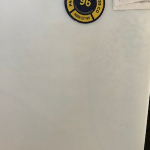 May include: A white surface with a circular sticker featuring the text "PAUL WISSMACH GLASS CO" and "96". A smaller label reads "WISSMACH 96" and "3MM".