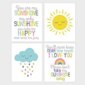 May include: Four printable wall art prints with a sunshine theme. The first print features a yellow sun with a smiling face and the text "You are my sunshine, my only sunshine, you make me happy when skies are grey". The second print features a blue cloud with a smiling face and raindrops in various colors. The third print features a rainbow and the text "You'll never know dear how much I love you". The fourth print features a rainbow and the text "Please don't take my sunshine away".