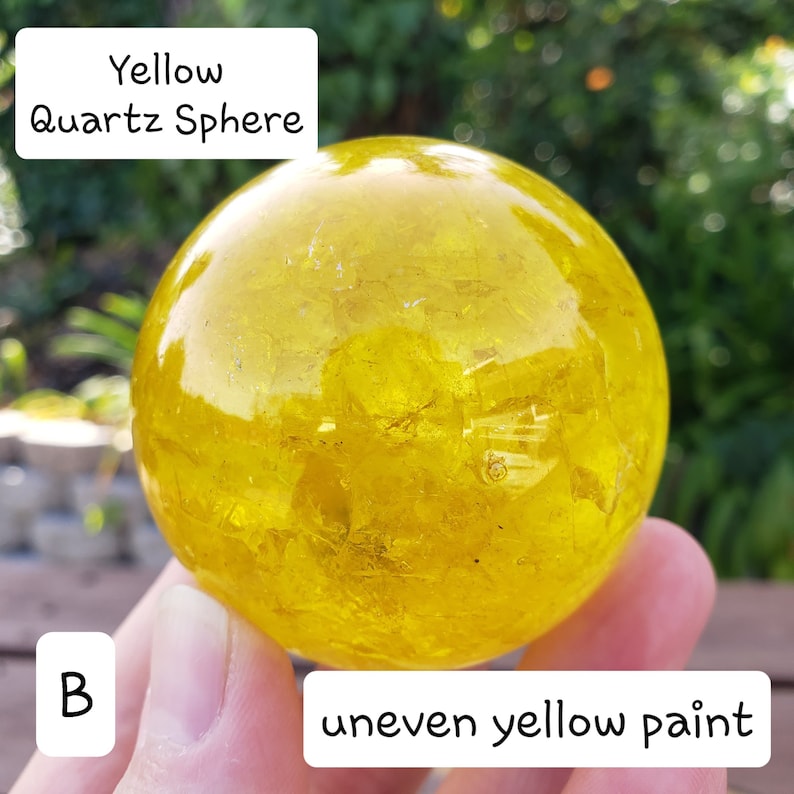 May include: A yellow quartz sphere with uneven yellow paint. The sphere is round and appears to be made of a translucent material. Text on the image reads "Yellow Quartz Sphere" and "uneven yellow paint".