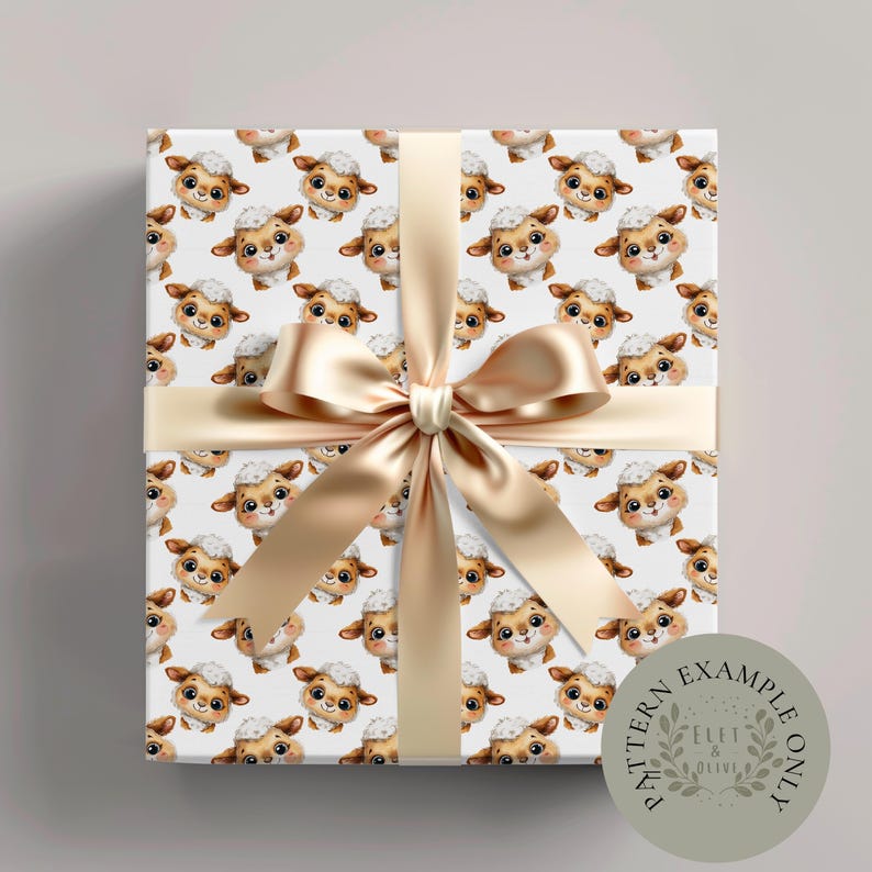 May include: A wrapped gift with white wrapping paper featuring a repeating pattern of cartoon sheep. The gift is tied with a gold satin ribbon and bow. A circular stamp in the lower right corner reads "Pattern Example Only" and "Eleft & Olive".