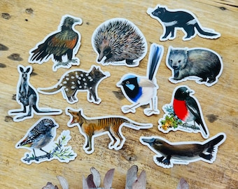 May include: A set of ten illustrated stickers featuring Australian animals and birds. The stickers include a platypus, echidna, kookaburra, quoll, Tasmanian devil, wombat,  kangaroo,  wattlebird,  and a wedge-tailed eagle.
