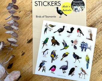 May include: A sheet of stickers featuring colorful illustrations of birds native to Tasmania. The stickers are packaged with a brown card that reads "Stickers, Birds of Tasmania, Made in Australia" and a logo for Pigment Monica Reeve.