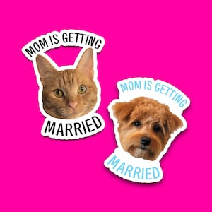 May include: Two stickers on a bright pink background. One sticker features an orange cat's face with the text "MOM IS GETTING MARRIED" in a curved font. The other sticker shows a brown dog's face with the same text in a blue font.
