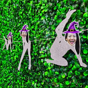 May include: A Halloween party banner with three witch silhouettes. Each witch has a different face and a purple witch hat. The banner is made of silver glitter paper.