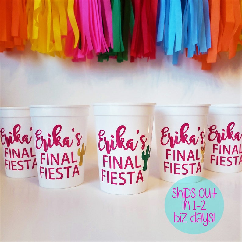 May include: Four white plastic cups with the text "Erika's Final Fiesta" in pink and gold lettering. Each cup has a small cactus graphic.
