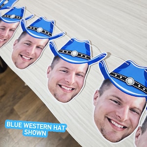 May include: A string of blue cowboy hat cutouts with a smiling face printed on each. The hats have a black band with white dots and a silver buckle. The text "BLUE WESTERN HAT SHOWN" is visible.