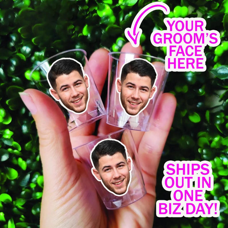 May include: Three clear plastic shot glasses, each featuring a circular sticker with a photograph of a man's face. The text on the image reads: YOUR GROOM'S FACE HERE and SHIPS OUT IN ONE BIZ DAY. The glasses are held together in a cluster.