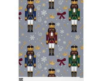 May include: A fabric with a repeating pattern of nutcracker figures in blue, green, and red uniforms, each with a gold crown. The background is light grey with gold keys, snowflakes, and bows.