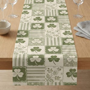 Könnte beinhalten: Ein weißer Keramikbecher mit schwarzem Henkel und dem Text "But First, Coffee" in schwarzer, handschriftlicher Schrift. Der Becher fasst wahrscheinlich 310-425 ml und steht auf einer weißen Oberfläche.