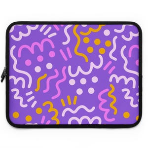 May include: A rectangular laptop sleeve with a purple background featuring a repeating pattern of light pink, bright pink, and mustard yellow squiggly lines, short dashes, and solid circles. The sleeve has a black zipper along the left side.