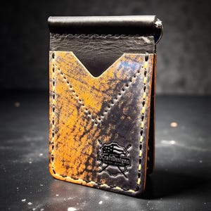 May include: A handcrafted leather wallet with a money clip. The wallet features a distressed orange and black design with yellow stitching. The logo "DCraftDesigns" is visible on the front.
