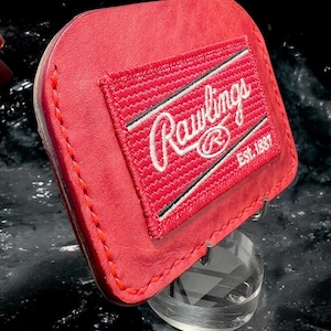 May include: Red leather wallet with a Rawlings logo and the text "Est. 1887".