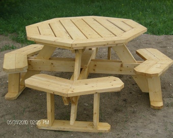 Op de afbeelding: Achtekantige houten picknicktafel met vier banken. De tafel en banken zijn gemaakt van onafgewerkt licht hout. De tafel heeft een diameter van 183 cm.