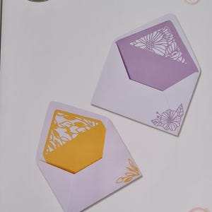 May include: A pack of six die-cut envelope designs featuring a floral pattern. The pack is labelled "Sizzix Thinlits" and includes the product number "665176".