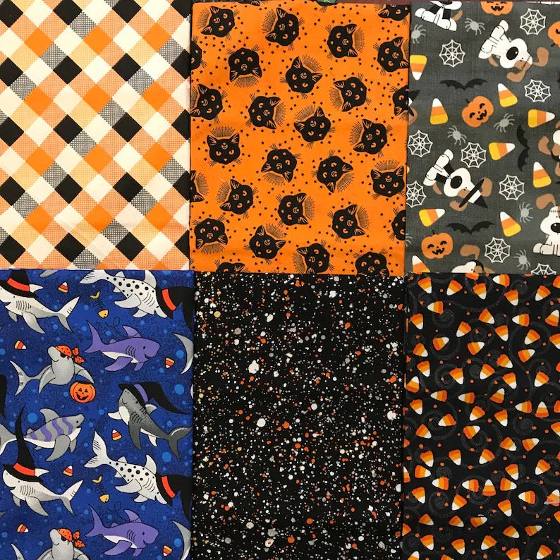 K&ouml;nnte beinhalten: Ein Patchwork aus quadratischen Stoffen zum Thema Halloween. Muster sind orange und schwarzes Karomuster, schwarze Katzen auf Orange, Halloween-Hunde, Haie mit Hexenh&uuml;ten, wei&szlig;e Sprenkel auf Schwarz und Zuckermais.