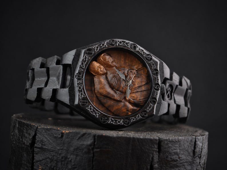May include: A black wooden wristwatch featuring a carved brown wood dial depicting two figures in an embrace. The watch case and link band are crafted from dark wood with intricate Celtic knotwork patterns engraved around the circular watch face.