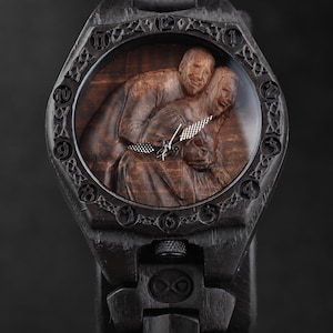May include: A dark wood wristwatch featuring a carved relief of two people embracing on the dial. The bezel displays engraved numbers and intricate knotwork patterns. The watch includes silver-toned hands and a matching dark wood link bracelet.
