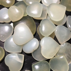 May include: A collection of white heart-shaped stones. The stones are smooth and polished, and they have a translucent appearance.