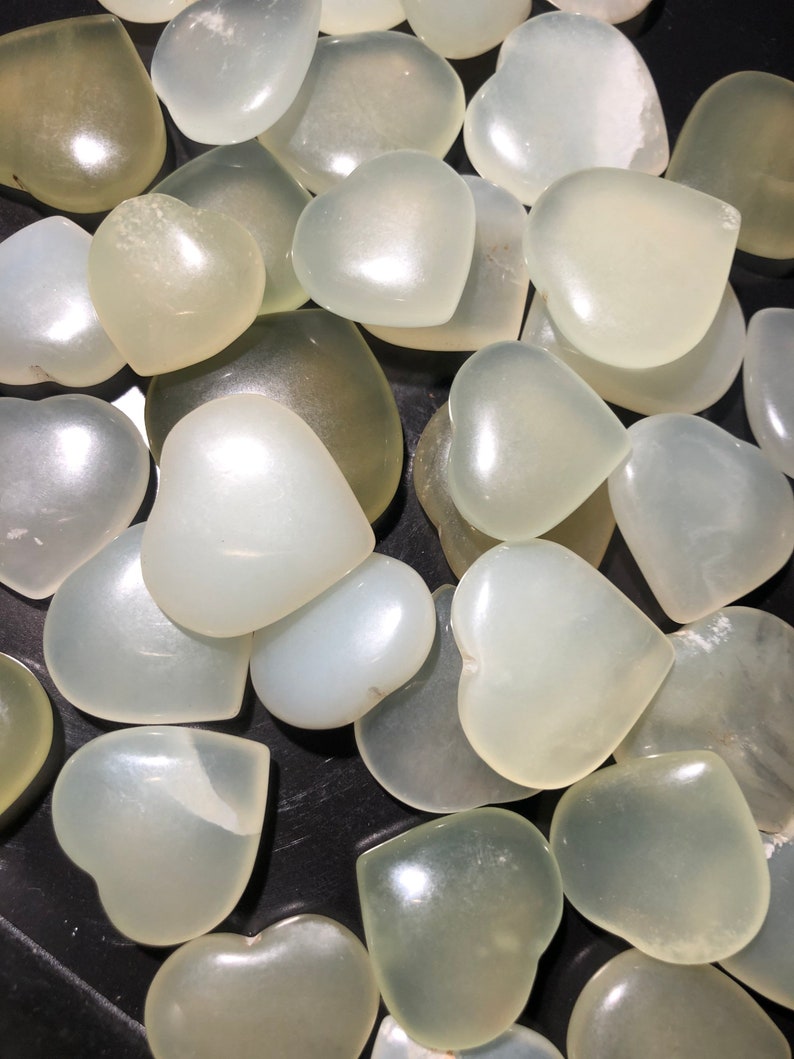 May include: A collection of white heart-shaped stones. The stones are smooth and polished, and they have a translucent appearance.