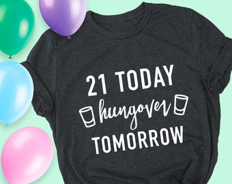 May include: A dark gray t-shirt with white text that reads "21 TODAY hangover TOMORROW" with a shot glass graphic on either side of the word "hangover".