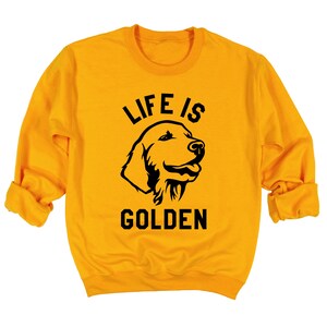 May include: A yellow sweatshirt with black text that reads "Life is Golden" and a black silhouette of a golden retriever dog's head.