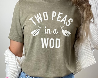 May include: A green t-shirt with the text "Two Peas in a Pod" in white lettering. The shirt features a pea pod graphic on each side of the text.