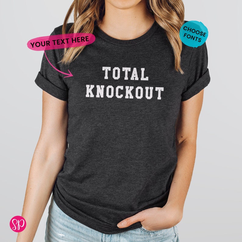 May include: A dark heather grey t-shirt with white text that reads "TOTAL KNOCKOUT".