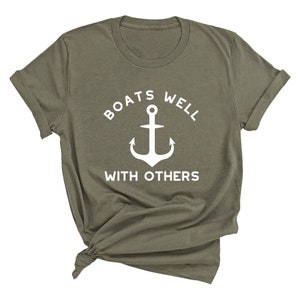 May include: A green t-shirt with a white anchor and the text "BOATS WELL WITH OTHERS".