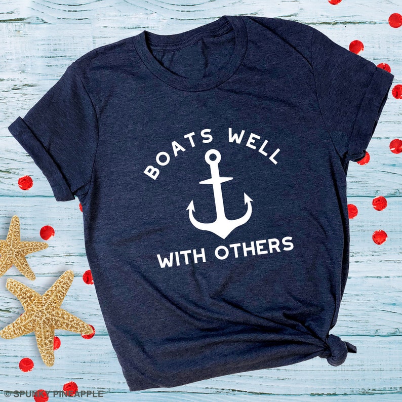 May include: A navy blue t-shirt with a white anchor and the text "Boats well with others".