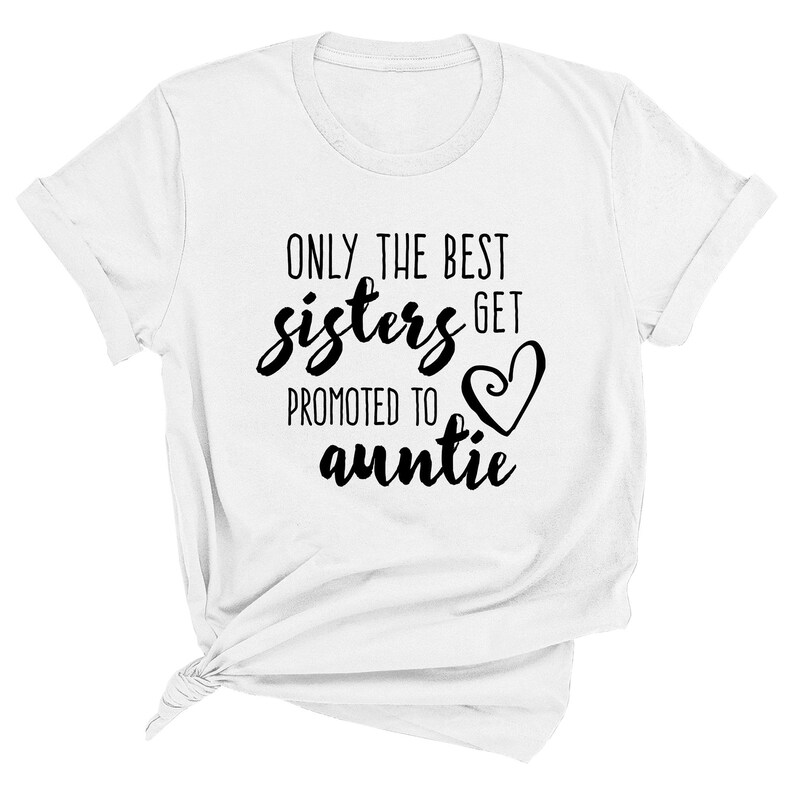 May include: White t-shirt with rolled sleeves. The text "ONLY THE BEST sisters GET PROMOTED TO auntie" is printed in black script and block letters, with a heart symbol. A casual, everyday wear item.
