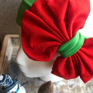 Puede incluir: Una diadema con lazo rojo y banda verde. El lazo es grande y de tela suave. Un accesorio con tem&aacute;tica navide&ntilde;a.