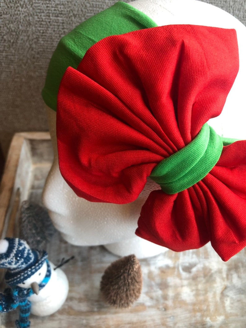 Puede incluir: Una diadema con lazo rojo y banda verde. El lazo es grande y de tela suave. Un accesorio con tem&aacute;tica navide&ntilde;a.
