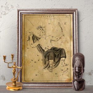 Könnte beinhalten: Ein gerahmter Vintage-Druck des Sternbilds Cepheus mit einer detaillierten Illustration der mythologischen Figur. Der Druck befindet sich in einem braunen Holzrahmen. Ein goldener Kerzenhalter und eine dunkle Holzbüste stehen auf dem Tisch.