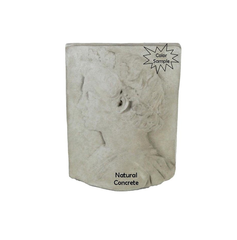 May include: A gray concrete wall sculpture of a woman's face in profile. The sculpture is mounted on a wall and has a natural concrete finish. The text "Natural Concrete" is printed below the sculpture.