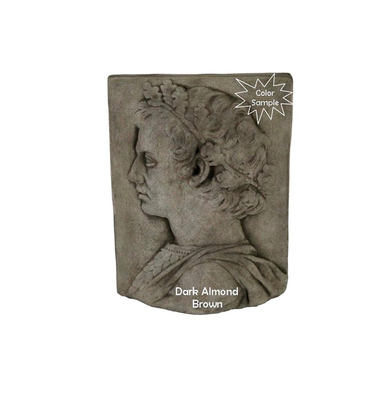 May include: A stone relief sculpture of a woman's head in profile, with a crown of leaves. The sculpture is painted in a dark almond brown color. "Color Sample" is written on a starburst sticker in the upper right corner of the image. "Dark Almond Brown" is written below the sculpture.