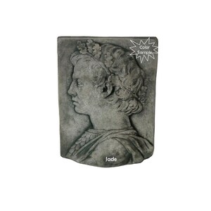 May include: A gray stone wall plaque with a detailed relief sculpture of a person's head and shoulders. The person is wearing a crown and a robe. The plaque is labeled "Jade".