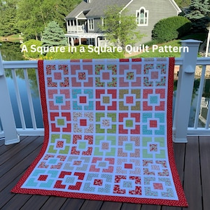 May include: A red, white, and green quilt with a "Square in a Square" pattern. The quilt is made of various floral fabrics and is hanging on a white railing.