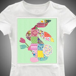 Puede incluir: Una camiseta blanca con un dise&ntilde;o de conejo de patchwork colorido en la parte delantera. El conejo est&aacute; hecho de cuadrados de tela de diferentes colores y tiene una flor rosa detr&aacute;s.