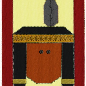 May include: A felt appliqué of a Native American headdress with a brown face, black eyes, and a black feather. The headdress is black with a gold band and two black feathers on the sides.