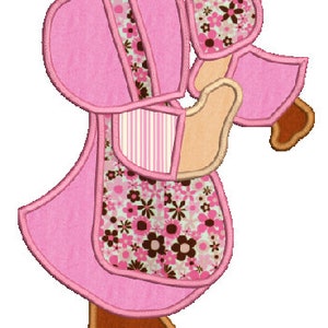 Puede incluir: Una aplicación de patchwork rosa y marrón de una niña con un vestido y sosteniendo una flor. La niña tiene el pelo marrón y la cara marrón.