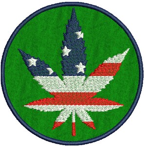 May include: A green circle with a dark blue outline features a white, red, and blue marijuana leaf design. The leaf is styled to resemble the American flag.