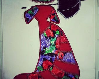 May include: Embroidered applique of a woman in a red dress with a floral pattern, holding a black umbrella. The applique is made of fabric and has a vintage style.