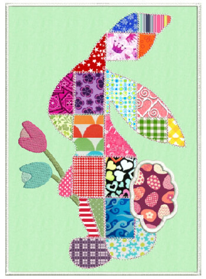 Puede incluir: Un conejito de patchwork con una flor en la boca. El conejito est&aacute; hecho de diferentes telas de colores con varios patrones, incluyendo lunares, rayas y corazones. El fondo es de color verde claro.