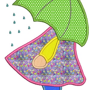 May include: An embroidered design of a child wearing a raincoat and holding an umbrella. The umbrella is green with white polka dots. The raincoat is purple with an Easter egg pattern, and the boots are blue.