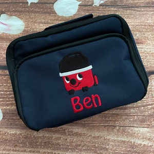 以下が含まれることがあります： 赤い掃除機と「Ben」という名前が刺繍された、紺色のランチバッグです。