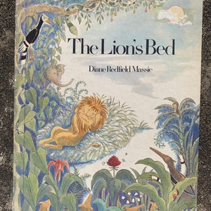 以下が含まれることがあります： ジャングルを背景に横たわるライオンが描かれた、カラフルなイラストの子供向け本の表紙。本のタイトルは「The Lion's Bed」、作者はダイアン・レッドフィールド・マッシーです。