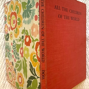 May include: A vintage book titled "ALL THE CHILDREN OF THE WORLD" with a red cover and a floral patterned spine and front cover. The spine also includes the author's name, DOSS.