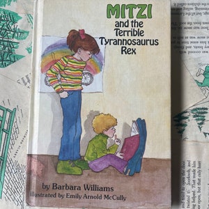 May include: A book cover featuring an illustration of two children. The book is titled "Mitzi and the Terrible Tyrannosaurus Rex" and is written by Barbara Williams and illustrated by Emily Arnold McCully.