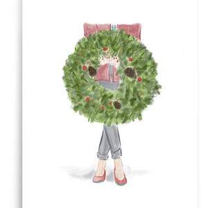 May include: A woman in a red sweater and blue jeans holds a green Christmas wreath in front of her.